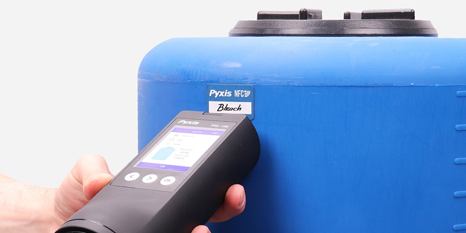 Pyxis PRL-100 portable radar level sensor scanning an NFC tag on a chemical storage tank